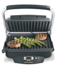 Hamilton Beach Steak Lover Electric Indoor Grill with seared steaks and grilled asparagus on nonstick surface.
