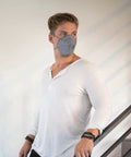 Man wearing gray N95 Disposable Respirator Mask Made In USA Super Comfy Fit Breathable Skin Friendly Nonwoven Fabric NIOSH Approved