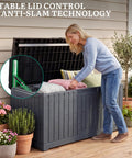 Woman placing cushions in Extra Large 120 Gallon Outdoor Storage Deck Box With No Sweat Hydraulic Lift Lid Heavy Duty All Weather Patio Organizer.