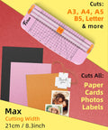 Pink A5 Paper Cutter Guillotine With Side Ruler For Scrapbooking cuts A3 to A5 paper, cards, and photos shown on colorful background.