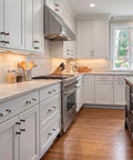 Modern kitchen featuring oil rubbed bronze glass cabinet pulls with 3 inch centers on white cabinets with silver appliances.