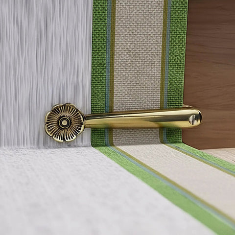 Stair Carpet Holder Clip with floral design in brass, holding a runner in place on a stair, part of a 5-inch pack of 13 clips.