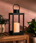 Outdoor Solar Lantern For Porch And Patio, Large Black Metal Lantern With Waterproof LED Candle, 14 Inches on wooden table