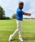Golfer using Golf Belt Laser And Rod Mount For Swing Training And Putting Alignment securely attached to hip on green field.
