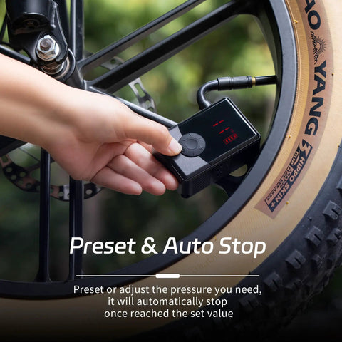 Hand using On The Go Portable Electric Mini Bike Pump With 130 PSI Gauge Auto Stop Digital Pressure Display for bike tire