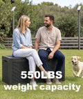 Couple sitting on 100 Gallon Resin Deck Box Lockable Outdoor Storage Chest, displaying 550 lbs weight capacity in garden setting.