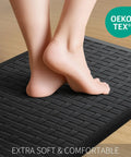 Bare feet on black cushioned mat, 2-Piece Cushioned Anti-Fatigue Kitchen Mats for Floor Waterproof Non-Slip Comfort Standing Rugs Built for Long Kitchen Shifts in Black 17.3x28 Inches Each