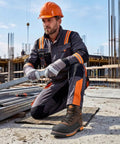 Construction worker wearing Men's Steel Toe Work Boots With Dual Layer Toe Protection And TPU Shield Non Slip Water And Oil Resistant Safety Boots For Industrial Jobs Welding And Warehouse EH Protected And Built To Last on a construction site.