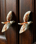 Two bird-shaped metal cabinet knobs on dark wood, Totally Cool Duck Shaped Metal Cabinet Knobs Set Of 2 Hand Painted Drawer Pulls.