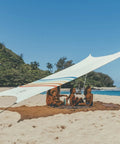 Family under a Grande Portable Beach Tent Sun Shelter with 81 Sq Ft Shade, enjoying sun protection at the beach.