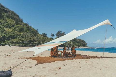 Family under a Grande Portable Beach Tent Sun Shelter with 81 Sq Ft Shade, enjoying sun protection at the beach.