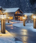 Weatherproof Aluminum Post Cap Lights For Deck And Yard With Bright Acrylic Diffuser illuminating a snowy pathway outside a home.
