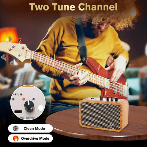 10W Mini Guitar Amp With Clean And Drive Channels on table, musician playing bass, USB-C rechargeable, headphone jack, wood finish
