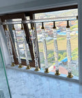 Acrylic Staircase Spindles Bundle With Killer Clear Bubble Design And Top Shelf Steel Hardware For Super Easy Indoor Outdoor Railing Install Includes Twenty Pieces And All Necessary Parts installed at a window view.