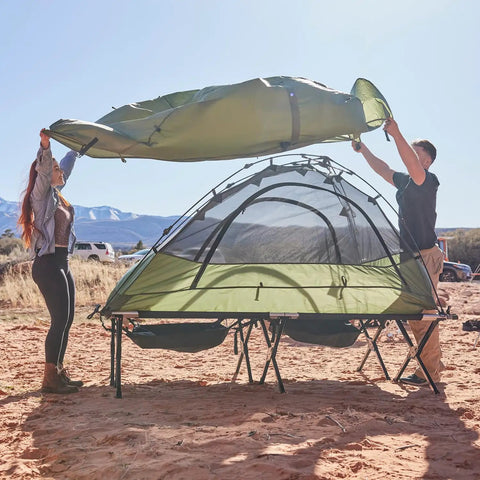Heavy Duty XXL Camping Cot For Adults With Pivot Arm Easy Setup shown in use at a campsite with green tent cover