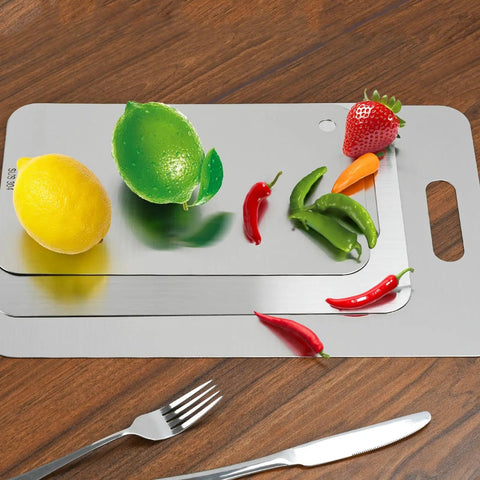 Three Piece Stainless Steel Cutting Board Set with fruits and vegetables on wooden table, showing different board sizes.