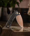 Koala Plus-BM Folding Knife With 2.99 Inch Blade For EDC And Camping, shown with black micarta handle and bronze blade.
