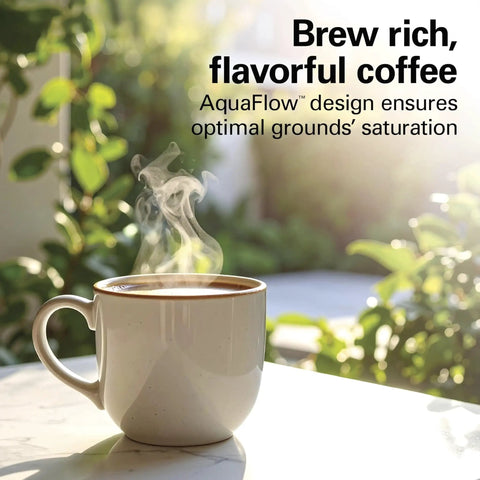 Cup of steaming coffee on a table showcasing AquaFlow design for rich flavor, plants in the background.