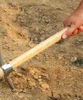 Stainless Steel Double Headed Pickaxe With Wooden Handle For Digging Loosening Soil Transplanting Planting Camping And Prospecting A Real Yard Workhorse For Gardeners being used to dig soil.