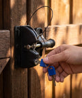 JOINPAYA 1Set Two Sided Gate Latch, Key Lockable Gate Lock with Pull Cable, person inserting keys into lock on wooden gate.