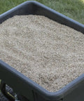 Pro Push Broadcast Spreader 85 Lb Capacity With Durable Plastic Hopper filled with seed, on grass surface