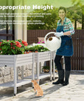 Person watering vegetables in an Elevated Raised Garden Bed With Locking Wheels, Large Resin Outdoor Planter Box Stand