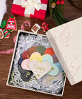 Fourteen Genuine Leather Heart Bookmarks With Uplifting Bible Verses set in a gift box with shredded paper, featuring various colors.