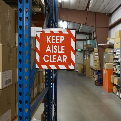 Magnetic Sign Holder Pack For 12 Inch Signs With 90 Degree Magnetic Base And 12 Inch Acrylic Strip For Door Frames And Metal Shelves Quick And Easy Sign Swaps In A 6 Pack 2.28 Inch Long By 0.79 Inch Wide By 13 Inch High displaying 'Keep Aisle Clear' sign in warehouse.