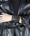 Badass 3 Piece Punk Gothic Leather Bracelet Set With Vintage Steampunk Spikes And Rivets Wide Adjustable Cuff Wristbands For Men And Women Daily Wear Gear worn on wrist with black leather jacket.