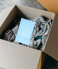 Milk Blue Bubble Mailers 11x15 Plus 4 Inch Self Seal Padded Envelopes in open box with clothing