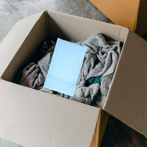 Milk Blue Bubble Mailers 11x15 Plus 4 Inch Self Seal Padded Envelopes in open box with clothing