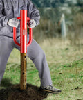 Person using Fence Post Driver And Pounder With Ergonomic Handles, 22Lb Heavy Duty Workhorse Carbon Steel Post Rammer on a wooden post.
