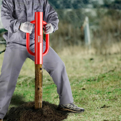 Person using Fence Post Driver And Pounder With Ergonomic Handles, 22Lb Heavy Duty Workhorse Carbon Steel Post Rammer on a wooden post.