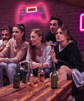 PS Controller Neon Light Sign For Gaming Rooms With Dimmer, LED Wall Decor in a cozy game room setting with friends.