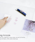 Clear PVC Desk Pad For Writing 23.6x13.7 Inches, Heat Resistant Waterproof Oil Proof Anti Static Desk Protector being cleaned with cloth