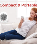 Woman relaxing on couch with Compact Personal Desk Heater visible. Cozy Personal Desk Heater For Office And Home Compact Space Heater With Three Modes.