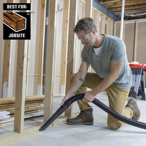 Man using Heavy Duty Wet Dry Vac Pro Attachment Kit For Two And A Half Inch Hoses With Seven Foot Dual Flex Hose Industrial Grade Shop Vacuum Accessories For Big Cleanups And Tough Projects in a workshop.