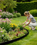 Person kneeling near garden with Pro Grade Landscape Edging Kit 33 Foot Long By 4 Inch High Flexible Plastic No Dig Border