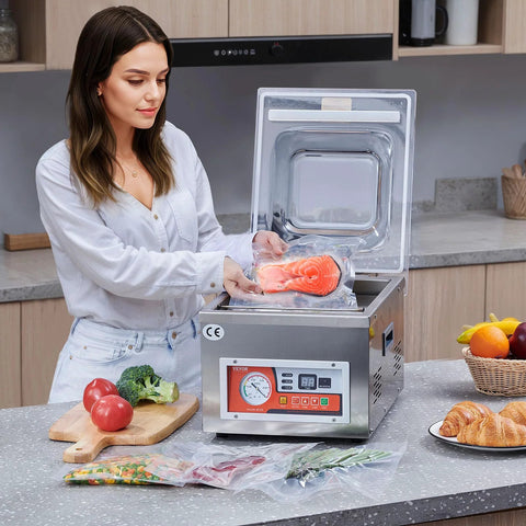 VEVOR chamber vacuum sealer in stainless steel on kitchen counter; person seals salmon fillet in a bag.