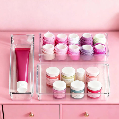 Big 26 Pack Drawer Organizer Bins In Clear Plastic, showing multiple bins with cosmetics and towels, on pink background