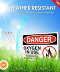Rock Solid Oxygen In Use Safety Signs With No Smoking Warning 10X7 Inch Rust Free Aluminum Wall Placards 2 Pack outdoors in grass.