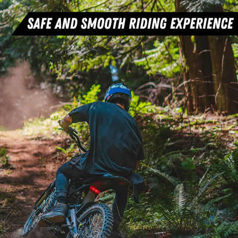 Person riding an e-moto bike through a forest, showcasing the Stem Lock For E Motos Bar Mount Kit Fits Talaria Sting Talaria XXX Surron Light Bee E Ride Pro SS 79Bike Falcon M Segway X260 With Stem Cap Spacers And Bolt In Multiple Color Options.