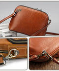 Close-up of a leather bag with 4 Pack Antique Brass D Rings And Ball End Studs Repair Kit For Purses Bags Leather Straps