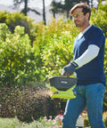 Person using OSS1800 Salt Spreader For Yard And Garden Semi Battery 18V One Plus, 2.5-3.5 Meter Broadcast Range, 4 Liter Capacity
