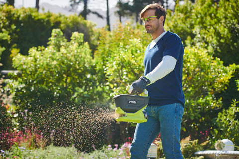 Person using OSS1800 Salt Spreader For Yard And Garden Semi Battery 18V One Plus, 2.5-3.5 Meter Broadcast Range, 4 Liter Capacity