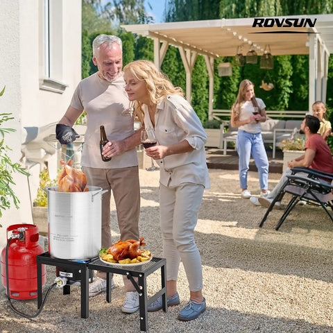 Outdoor gathering with Powerful Portable Propane Stove With Foldable Side Rack Single Burner preparing turkey by patio.