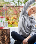 Alkaline Water Filter Cartridges 3 Pack BPA Free For Brita Pitchers And Other Brands Raises pH Adds Magnesium Improves Taste And Odor Easy Replacement For Fresh, Crisp H2O in use outdoors with a woman stretching nearby.