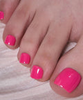 CurvLife Hot Pink Press On Toenails Short Square Glossy Soft Gel Fake Nails With Adhesive Tabs Natural Fit Reusable Salon Quality Toe Nails For Women Electric Fuchsia polished toes on soft surface