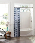 Bathroom with Sage Traditional Double Post Toilet Paper Holder Brushed Nickel Finish next to modern tub and blue shower curtain.