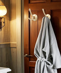 Gold Hat And Coat Hooks 4 Pack Heavy Duty Metal Wall Mounted Hangers For Coat Backpack Towel And Accessories In Bathroom Entryway Closet Or Garage Built From Rust Resistant Zinc Alloy With 40 Lb Capacity on a wooden door with towel